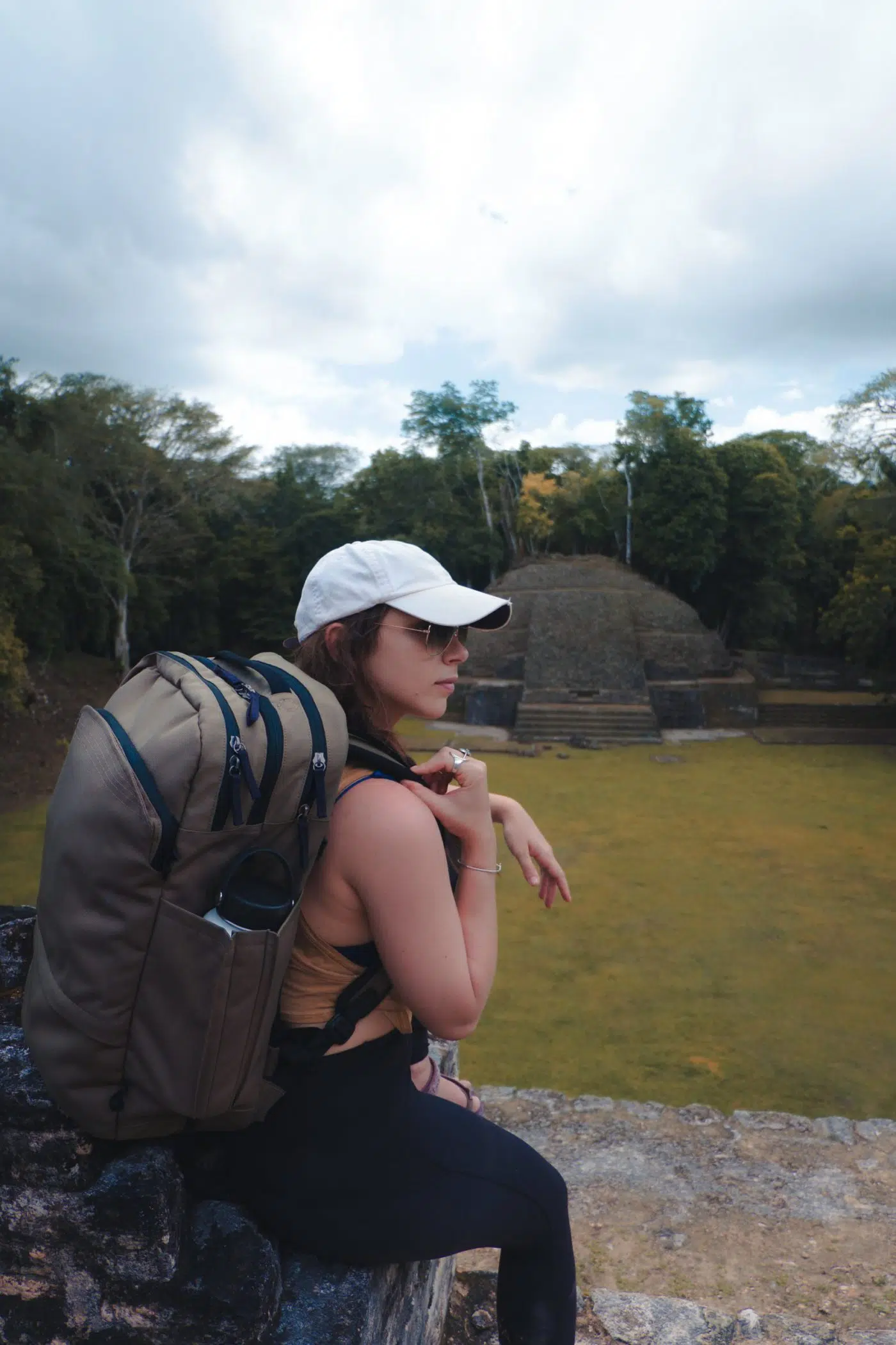 girl sitting on ruins at Caracol, Belize