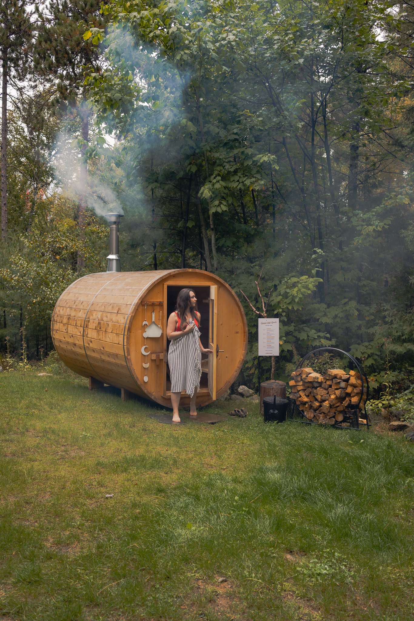 Girl stepping out of a cedar barrel sauna in the mountains of Upstate New York