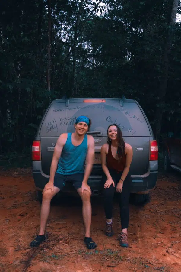Sitting on the bumper of a rental car in the jungle 
