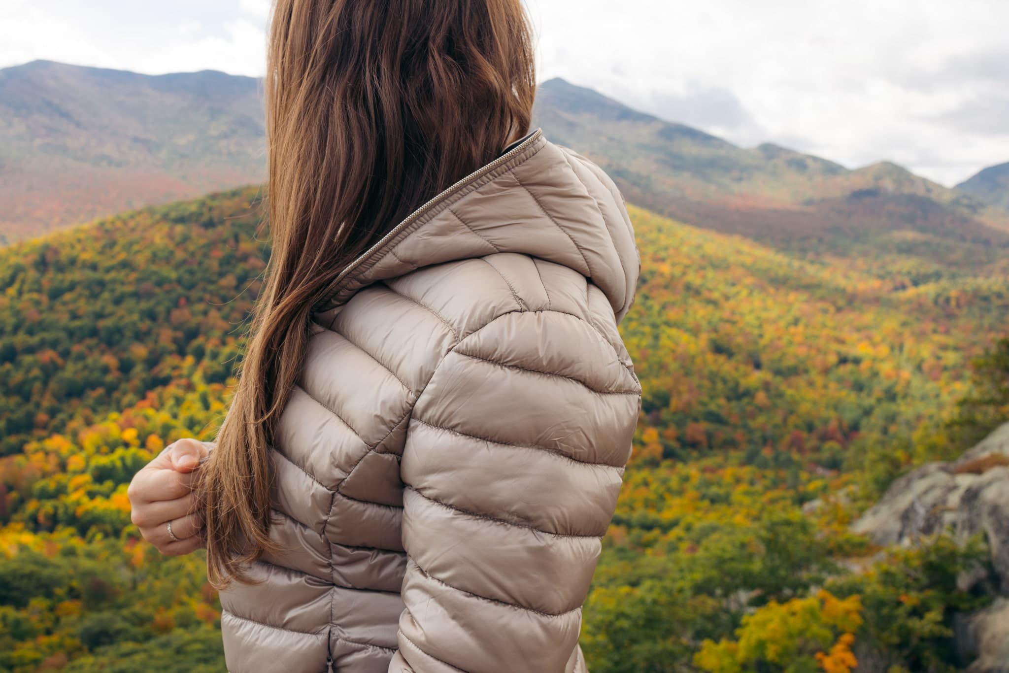 Hiker wearing a warm jacket that packs up small for a day hike in the Adirondack Mountains