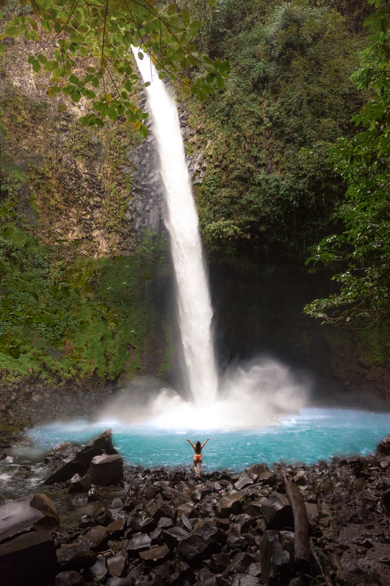 Woman standing at the base of La Fortuna Waterfall