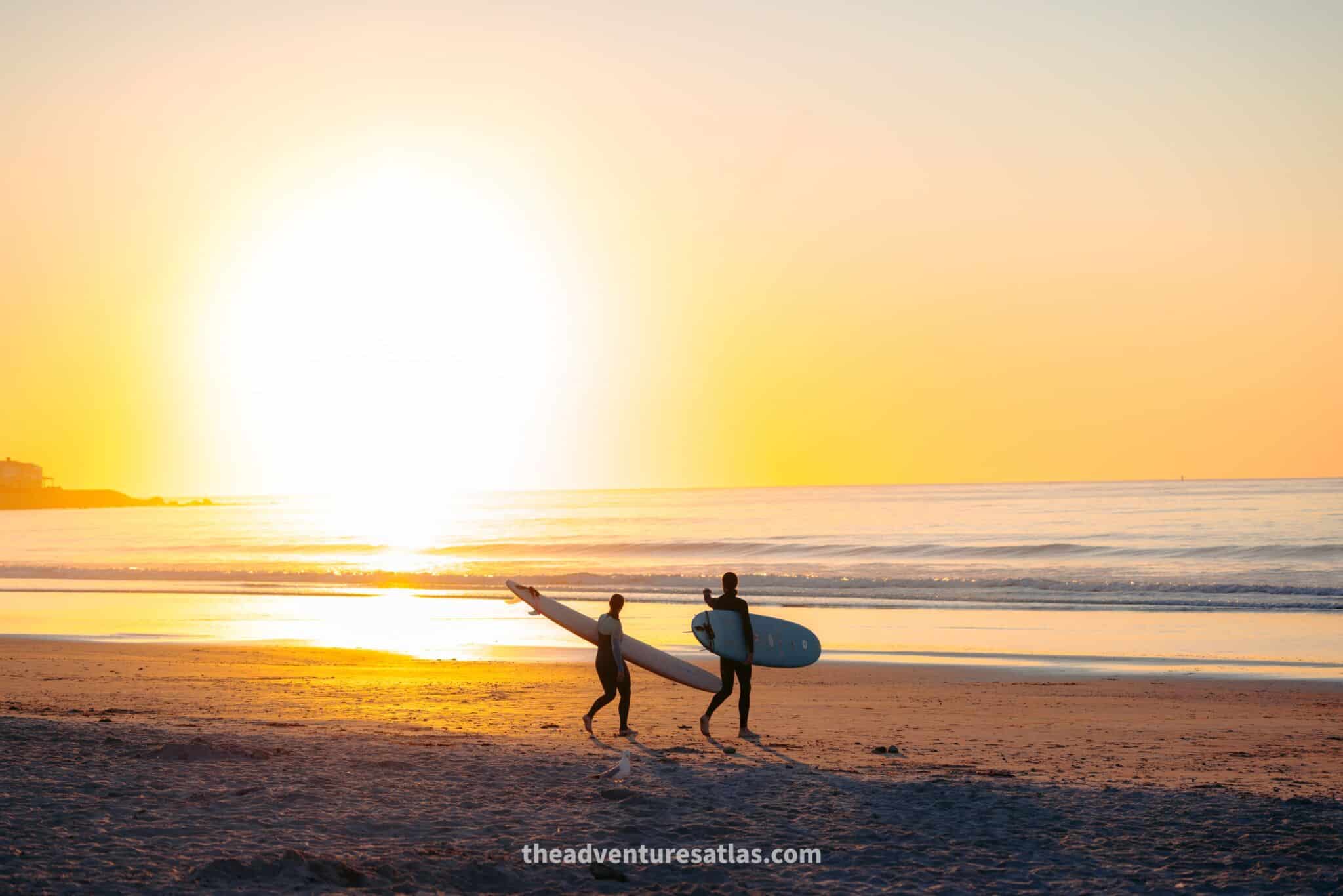 Two surfers at sunrise on Jenness Beach, NH