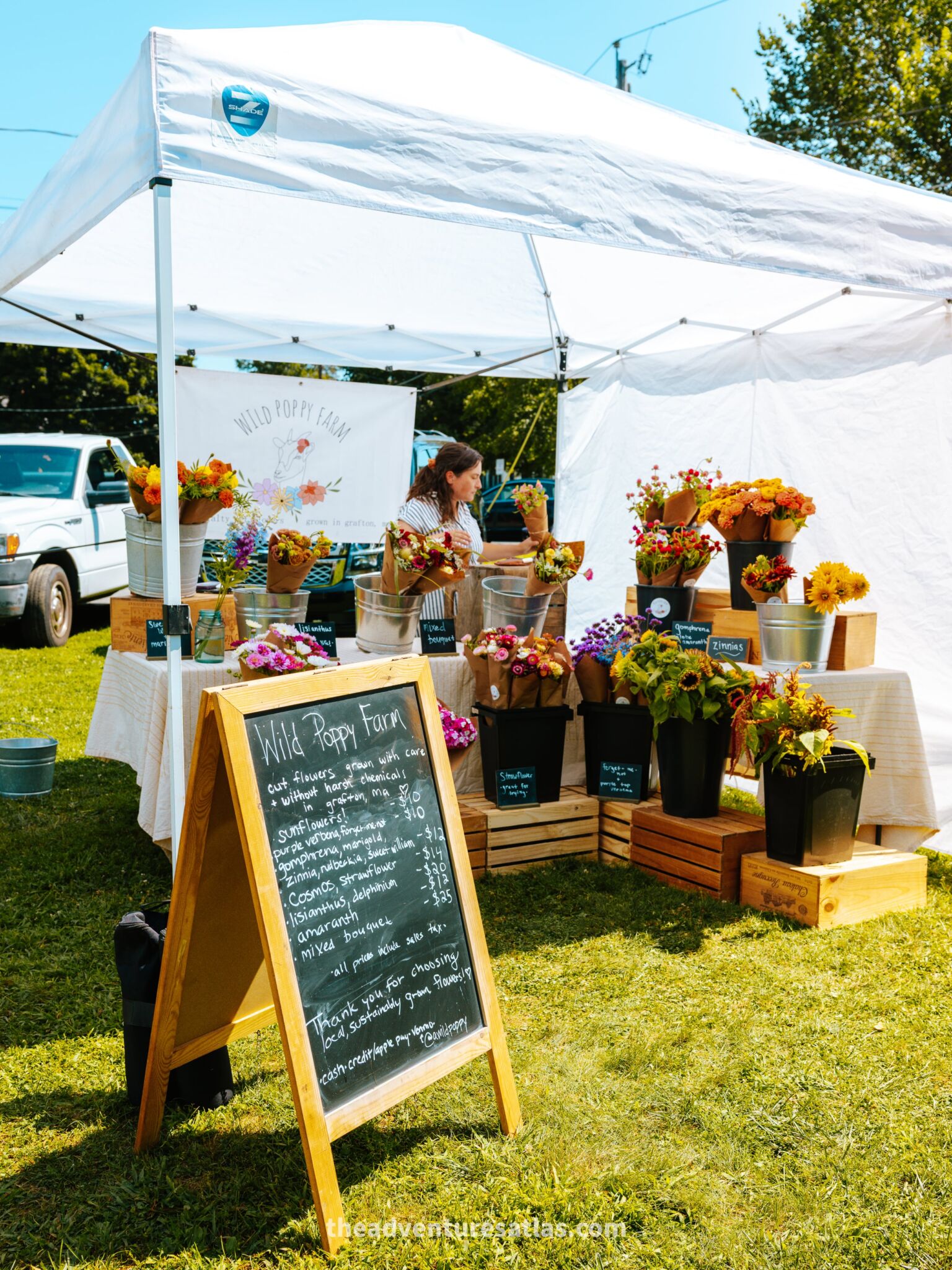 A vendor arranges flowers at a farmers market in the Berkshire Mountains