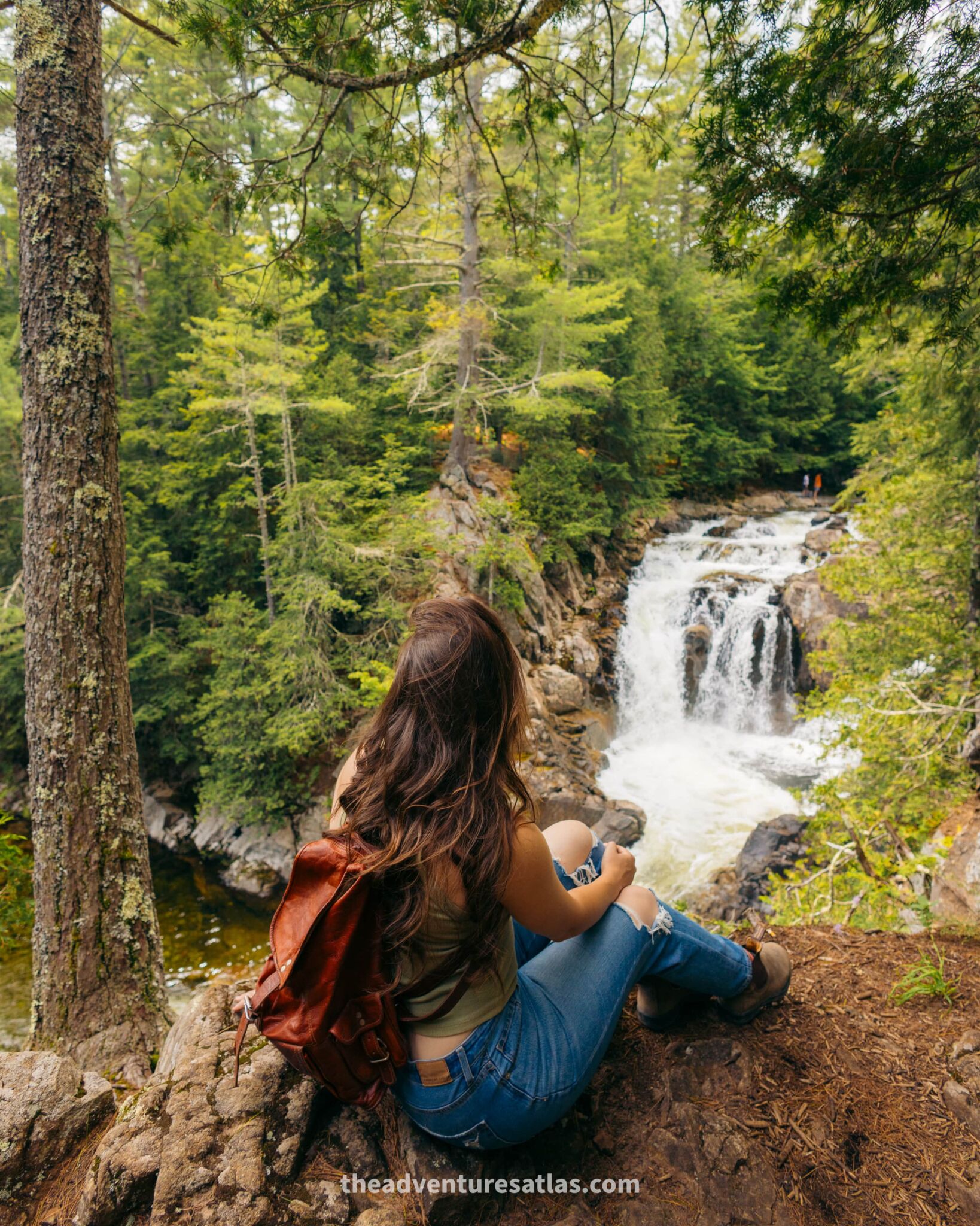 Sitting at the edge of a waterfall in the mountains of the northeast USA in the summer