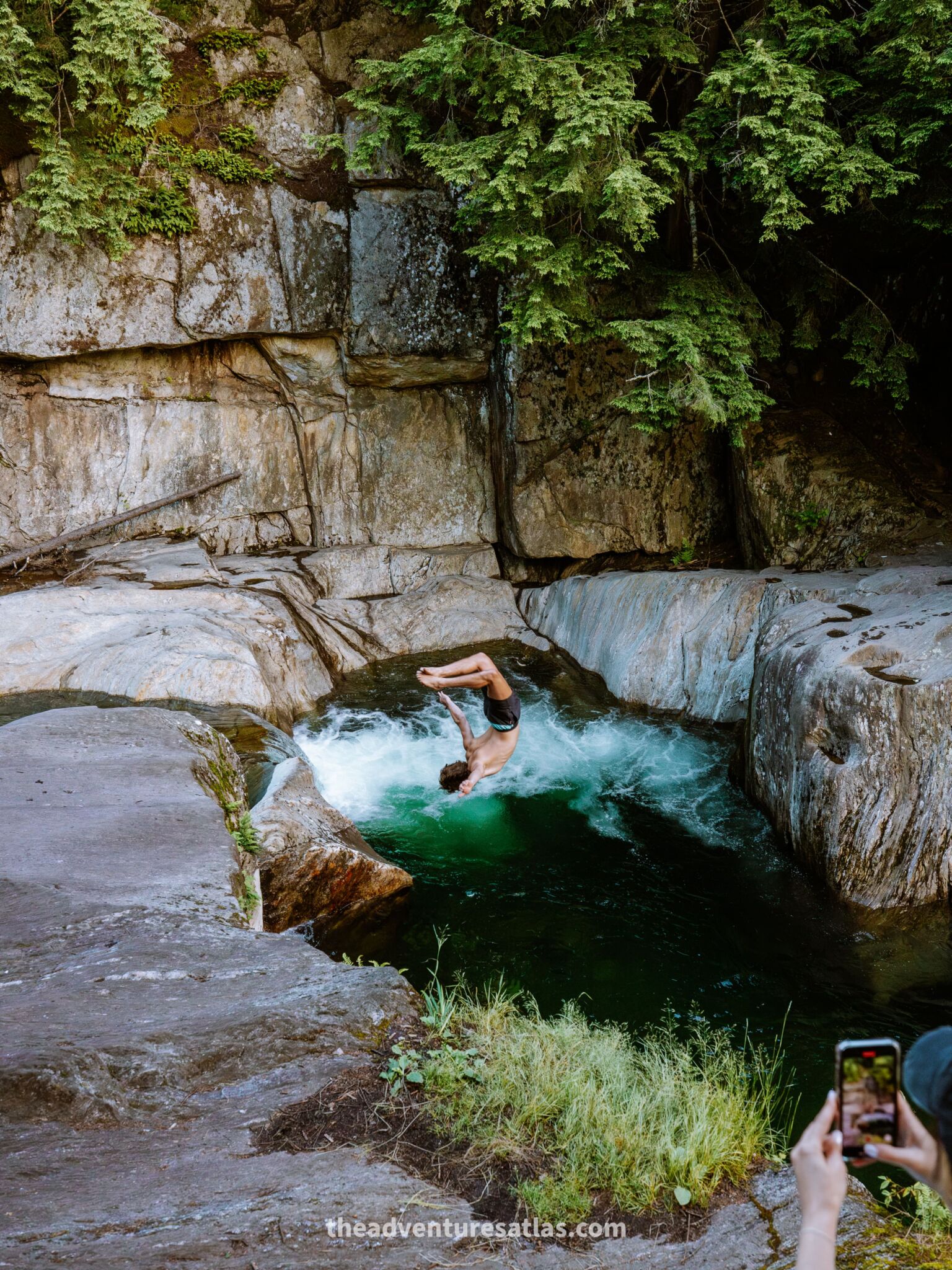 Jumping into a swimming hole in Vermont, the best place to visit in July in the United States