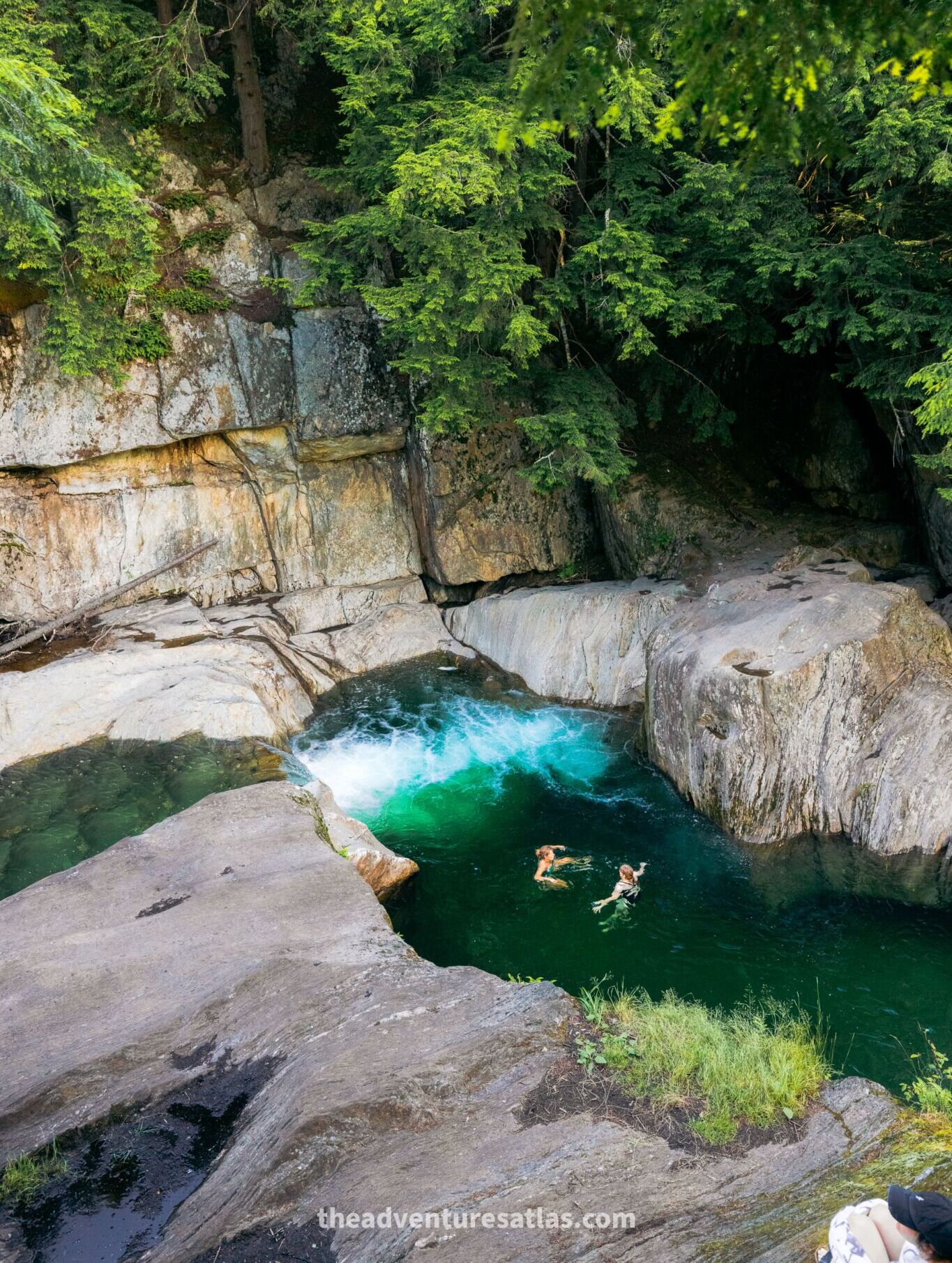 Two people swimming in Warren Falls in Green Mountain National Forest, Vermont in July