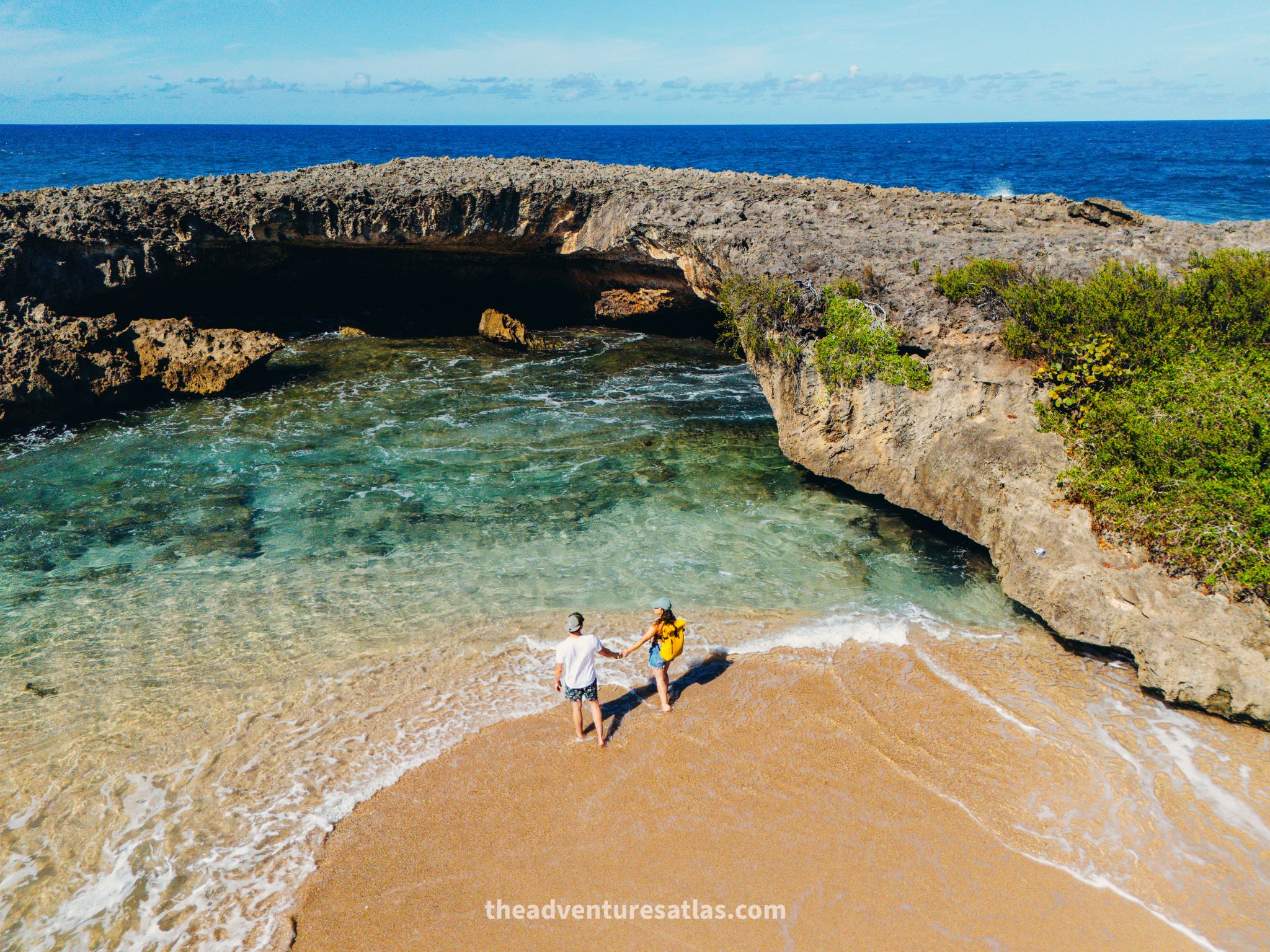 A couple hiking to secluded sea caves on a 3 day road trip itinerary on the north shore of Puerto Rico