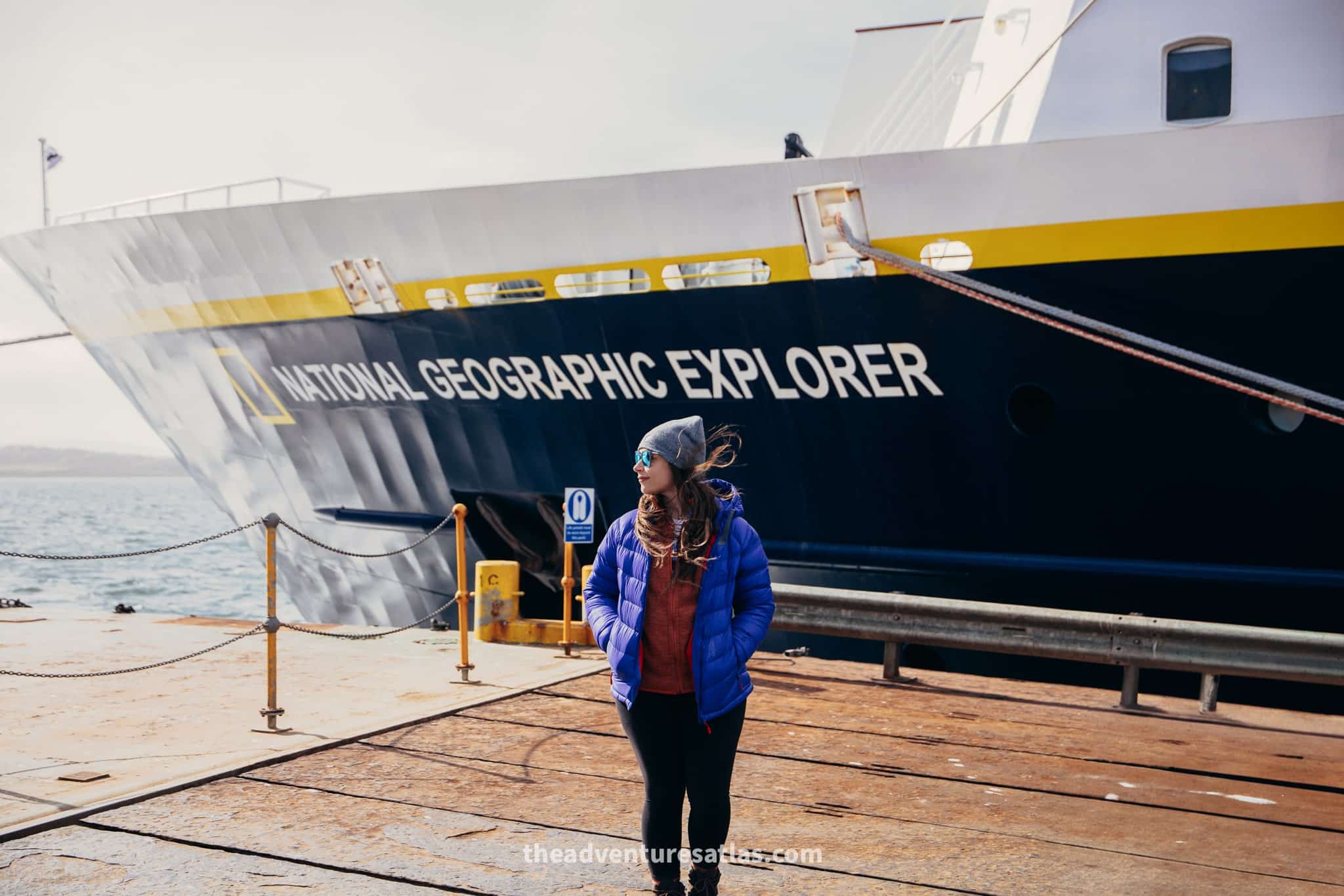 Woman standing in front of the National Geographic Explorer ship at the port